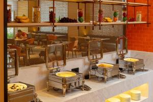 een restaurant met drie wastafels met eten erin bij Guangzhou Baiyun Airport Rezen Select Hotel in Huadu