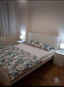 a bed in a bedroom with two night stands and two lamps at Apartman Bedem in Čačak