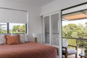 1 dormitorio con cama y ventana grande en A Perfect Stay - 1 James Cook Apartments, en Byron Bay