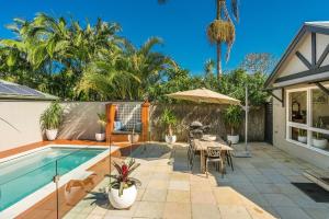 a backyard with a swimming pool and a table and chairs at A Perfect Stay - 3 Little Pigs in Byron Bay