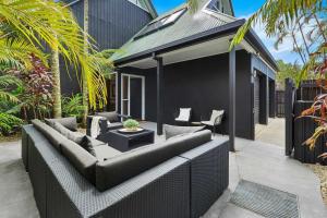 a patio with a couch and a table at A Perfect Stay - A Top Spot in Byron Bay