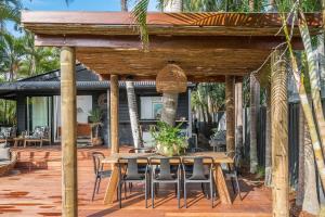 a wooden pergola with a table and chairs on a deck at A Perfect Stay - 3 Salty Sisters in Byron Bay