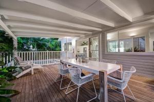 a porch with a table and chairs on a deck at A Perfect Stay - A Summer Cottage in Byron Bay