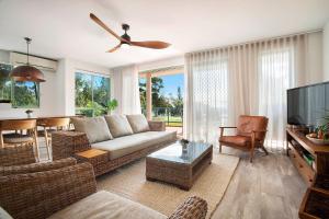 a living room with a couch and a flat screen tv at A Perfect Stay - Apartment 3 Surfside in Byron Bay