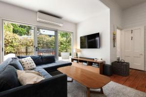 a living room with a blue couch and a table at A Perfect Stay Aaloka Bay in Byron Bay