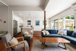 sala de estar con sofá azul y mesa en A Perfect Stay Aaloka Bay en Byron Bay