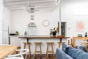 uma cozinha e sala de estar com um balcão e bancos em A Perfect Stay - Allure em Byron Bay
