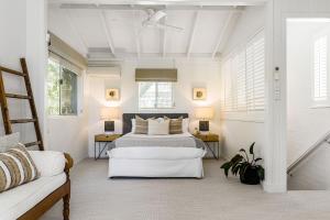 um quarto branco com uma cama e duas mesas em A Perfect Stay - Allure em Byron Bay