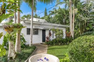 una casa blanca con palmeras en el patio en A Perfect Stay - Allure, en Byron Bay