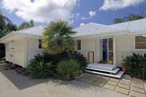 a house with a palm tree in front of it at A Perfect Stay - Abode at Byron in Ewingsdale