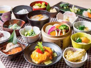 a table topped with bowls of different types of food at Mitsui Garden Hotel Kyoto Station in Kyoto