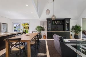 a kitchen and living room with a wooden table and chairs at A Perfect Stay - Arya in Byron Bay