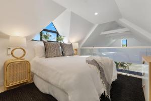 a white bedroom with a large bed and a window at A Perfect Stay - Arya in Byron Bay