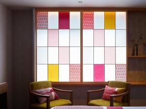 two chairs in front of a window with a colorful screen at Mitsui Garden Hotel Kyoto Station in Kyoto