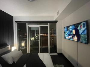 een slaapkamer met een bed en een tv aan de muur bij Home away from home in Toronto