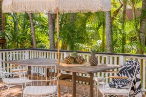 a wooden table and chairs with pineapples on it at A Perfect Stay - Banjos on Paterson in Byron Bay