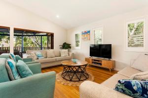 a living room with a couch and a tv at A Perfect Stay - Beach House at Tallows in Byron Bay