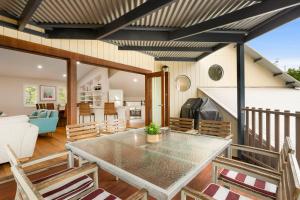 comedor y sala de estar con mesa y sillas en A Perfect Stay - Beach House at Tallows, en Byron Bay