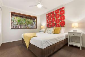 a bedroom with a large bed with a red headboard at A Perfect Stay - Beach House at Tallows in Byron Bay