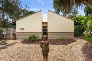 a statue of a person in front of a building at A Perfect Stay - Beach House at Tallows in Byron Bay