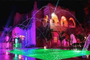 馬拉喀什的住宿－Riyad Anis - VacayX - MARRAKECH，前面有紫色和绿灯的建筑