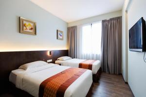 古晉的住宿－56酒店，酒店客房设有两张床和一台平面电视。