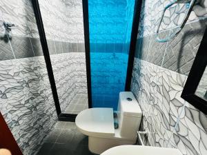 a bathroom with a toilet and a shower at Siargao By Grace Suites in General Luna