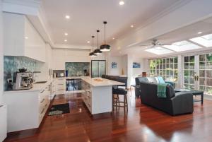 a kitchen and living room with a couch and a table at Camellia House - Elevator Access, Swimming, and Spa Pools in Nelson