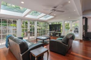 a living room with two couches and a tv at Camellia House - Elevator Access, Swimming, and Spa Pools in Nelson