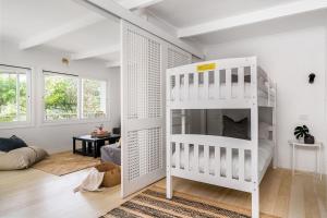 a white bunk bed in a white room at A Perfect Stay - Boardroom at Wategos in Byron Bay