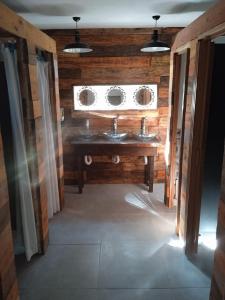 a bathroom with two sinks and a window at Casa Copada in Punta Del Diablo