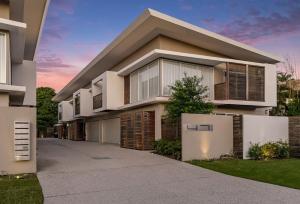 Una casa grande con una entrada para autos en frente de ella en Byron Sunrise - 4 BR retreat with heated pool, en Byron Bay