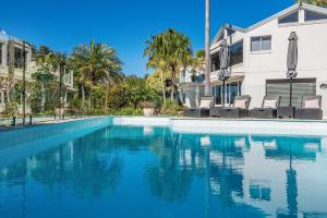 a swimming pool in front of a house at A Perfect Stay - Byron Pacific Vista in Byron Bay