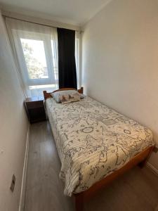 ein Schlafzimmer mit einem Bett in einem Zimmer mit einem Fenster in der Unterkunft Bella Lombarda in San Pedro de la Paz