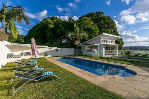 a group of lawn chairs next to a swimming pool at A Perfect Stay - Byrons Brae in Coorabell Creek