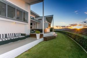 a house with a balcony with a view of the sunset at A Perfect Stay - Byrons Brae in Coorabell Creek