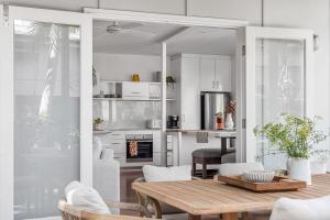 a kitchen and living room with a table and chairs at A Perfect Stay - Cape Cottage in Byron Bay