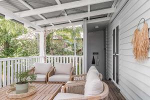 a porch with two chairs and a couch on it at A Perfect Stay - Cape Cottage in Byron Bay