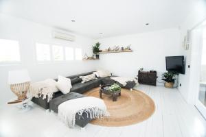 a living room with a couch and a tv at A Perfect Stay - Cactus Rose Villa in Byron Bay