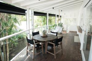 a dining room with a table and chairs on a balcony at A Perfect Stay - Cactus Rose Villa in Byron Bay