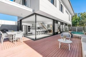 a house with a deck with a table and chairs at A Perfect Stay - Catalinas in Byron Bay