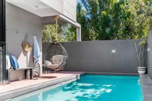 a patio with a swing and a swimming pool at A Perfect Stay - Catalinas in Byron Bay