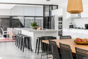 a kitchen with a wooden table and chairs and a counter at A Perfect Stay - Catalinas in Byron Bay