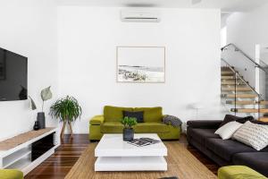 a living room with a couch and a table at A Perfect Stay - Clique 2 in Byron Bay