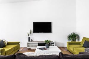 a living room with two couches and a tv on the wall at A Perfect Stay - Clique 2 in Byron Bay