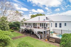 a white house with a slide and a yard at A Perfect Stay - Charlottes Web in Bangalow