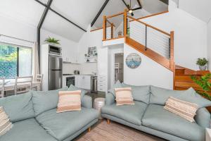 a living room with a couch and a staircase at A Perfect Stay - Gidgets House and Studio in Byron Bay