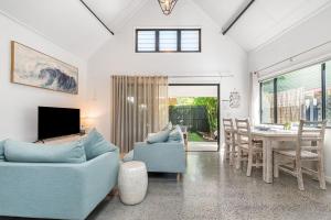 a living room with a blue couch and a table at A Perfect Stay - Gidgets House and Studio in Byron Bay