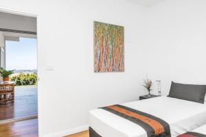 een slaapkamer met een bed en een schilderij aan de muur bij A Perfect Stay - Jali Burugar in Myocum
