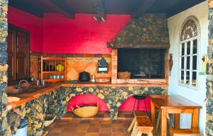 une cuisine aux murs rouges et un comptoir avec une table dans l'établissement Casa El Aljibe, à Puntagorda